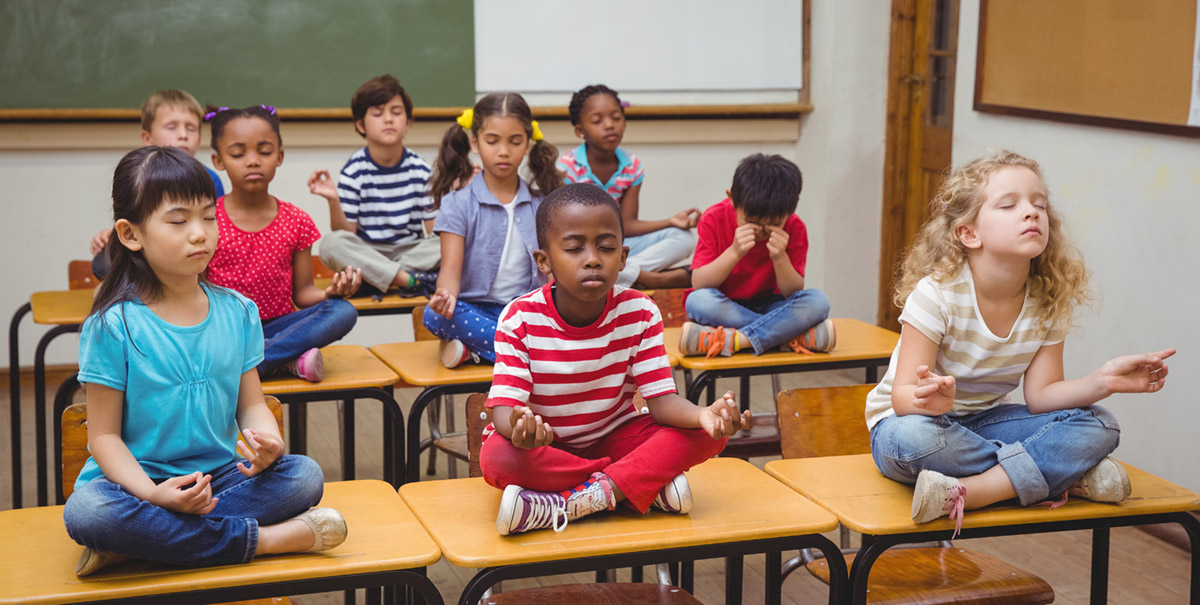 Schülerinnen im Klassenzimmer meditierend
